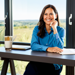 A professional woman in her late 30s, fully clothed in modest, comfortable business casual attire, sitting peacefully in a sunlit modern home office, looking out a large window at a serene landscape. She holds a warm cup, a gentle smile on her face, embodying a sense of calm and financial independence. The room is tidy and tastefully decorated, reflecting a balanced lifestyle. Perfect anatomy, correct proportions, natural pose, well-formed hands, proper finger count. Professional photography, high quality, vibrant colors, soft lighting, safe for work, appropriate content, family-friendly.